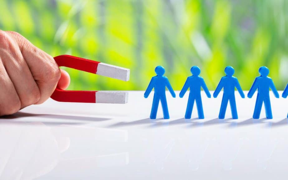 Businessman Attracting Human Figures With Horseshoe Magnet